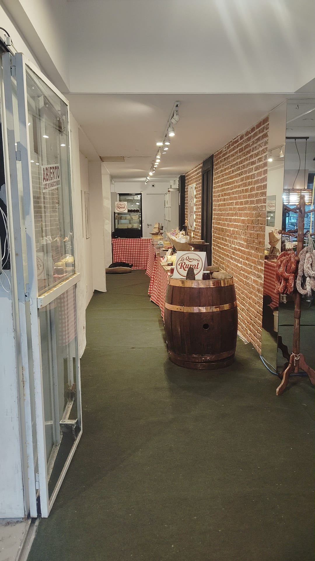 Interior del local con barril, mantel rural y puerta abierta